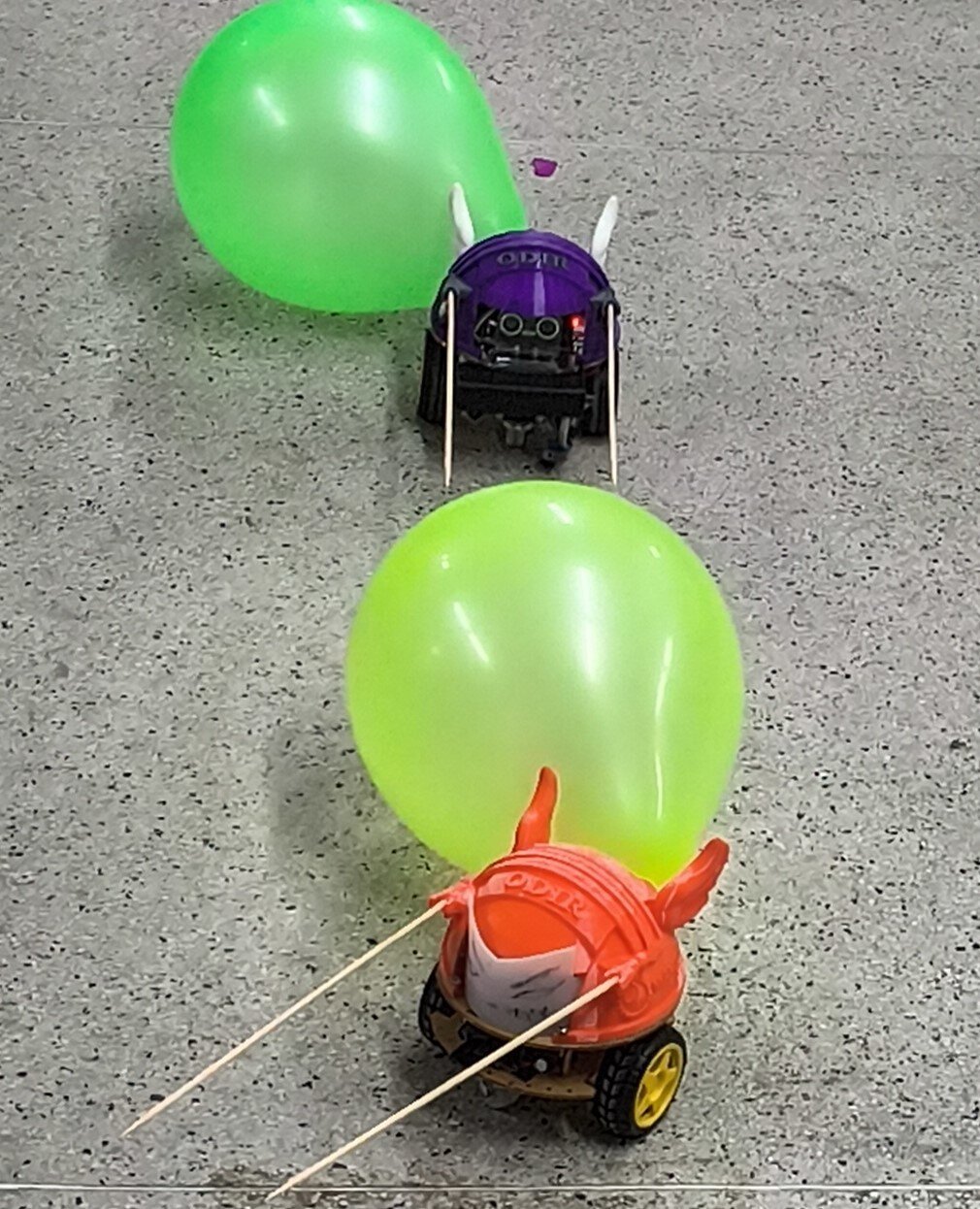 ODIR roxo com chifres e bexiga verde na arena de Duelo de Bexigas