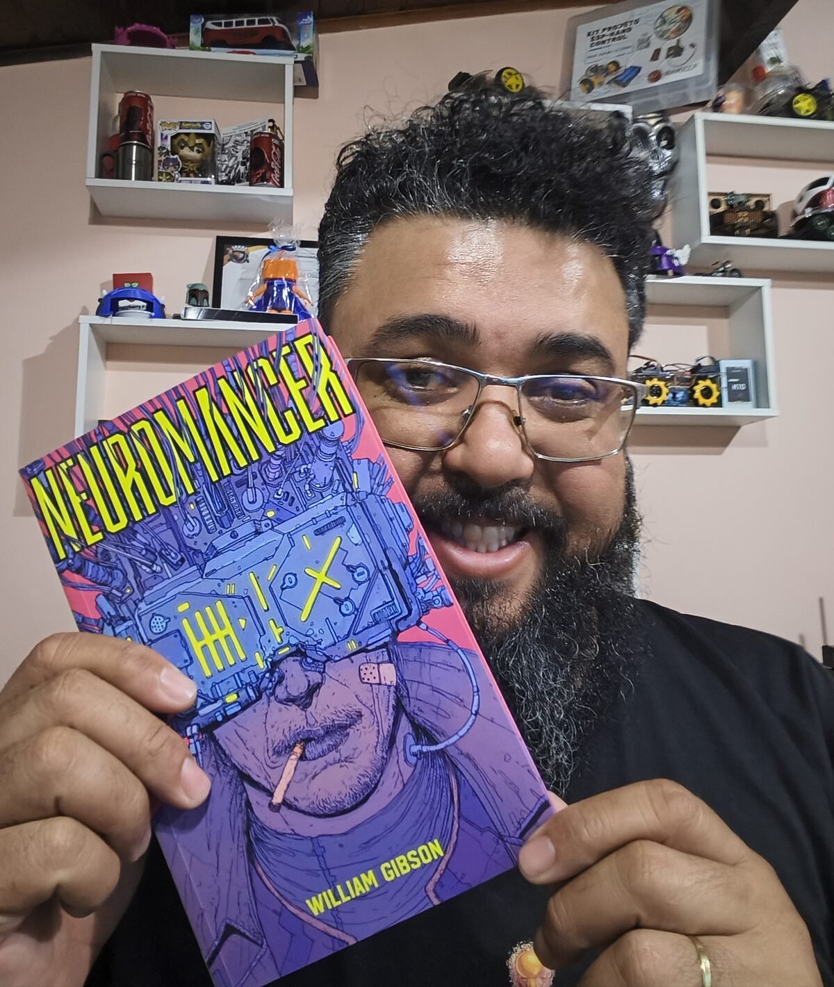 Tio Rafa segurando o livro Neuromancer, de William Gibson, edição da Editora Aleph